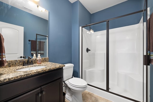 bathroom with toilet, vanity, and walk in shower