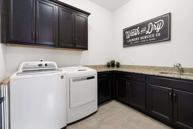 washroom featuring cabinets, sink, and washing machine and dryer