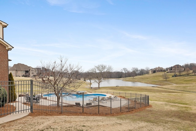 view of swimming pool featuring a water view and a yard