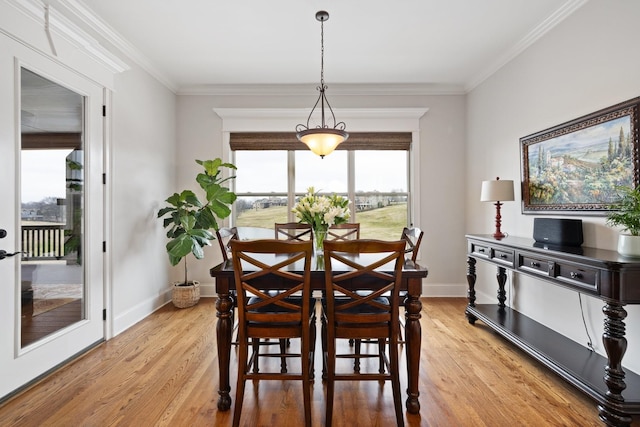 dining space featuring crown molding and light wood-type flooring