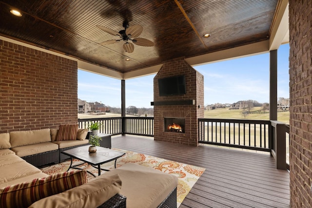 deck featuring an outdoor living space with a fireplace and ceiling fan