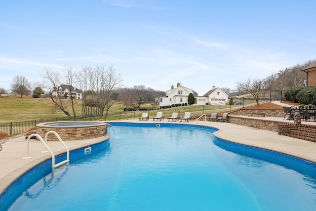 view of swimming pool featuring a patio area, a lawn, pool water feature, and an in ground hot tub