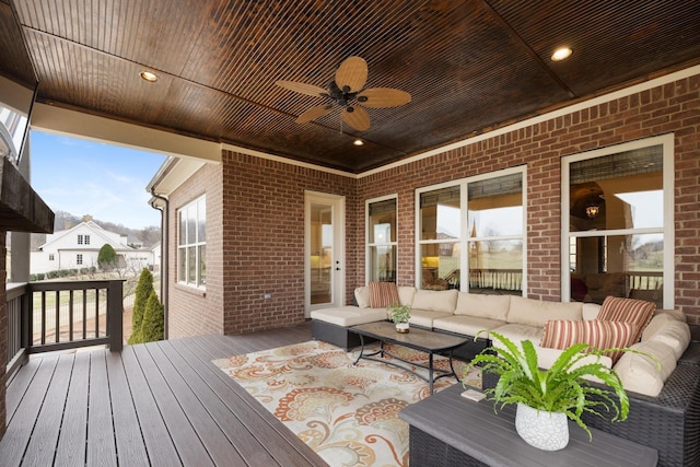 wooden terrace with ceiling fan and an outdoor living space