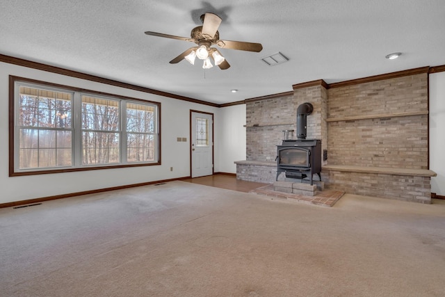 unfurnished living room with a textured ceiling, carpet floors, a wood stove, and ceiling fan