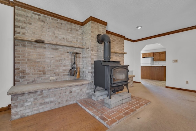 details featuring a textured ceiling, crown molding, wood-type flooring, white fridge, and a wood stove