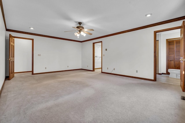 carpeted spare room with ceiling fan and crown molding