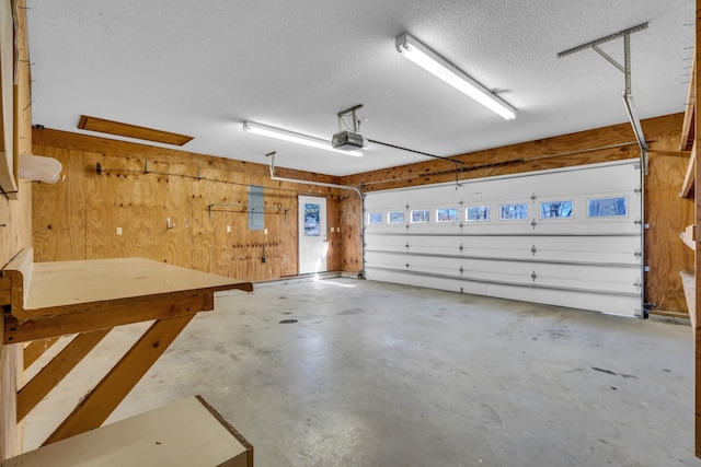 garage with a garage door opener and wooden walls