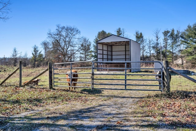 view of gate featuring an outbuilding and a rural view