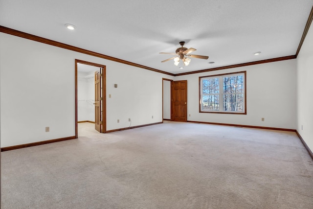 carpeted empty room with ceiling fan and ornamental molding