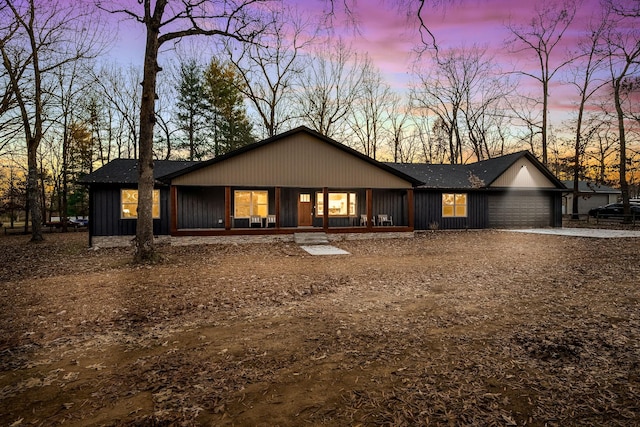 ranch-style home featuring covered porch and a garage