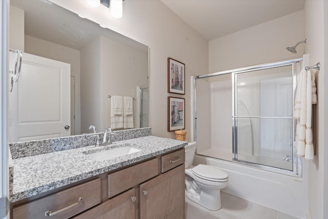 full bathroom featuring tile patterned flooring, vanity, toilet, and combined bath / shower with glass door