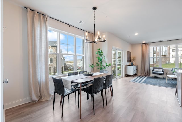 dining room with a chandelier, light hardwood / wood-style flooring, and plenty of natural light