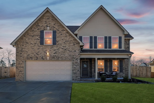 front of property with a lawn, a porch, and a garage