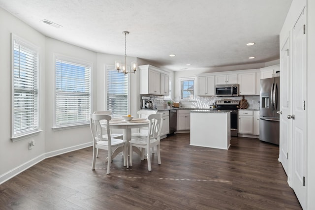 dining space with dark hardwood / wood-style flooring and a chandelier