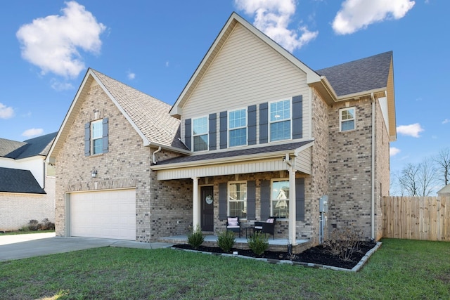 view of front of home with a porch, a garage, and a front yard