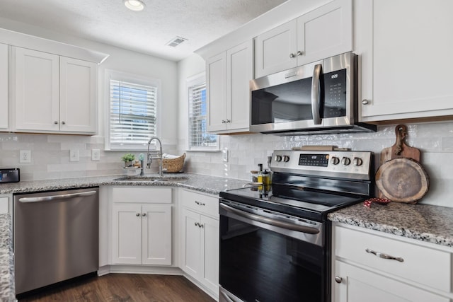 kitchen featuring light stone countertops, sink, white cabinetry, and stainless steel appliances