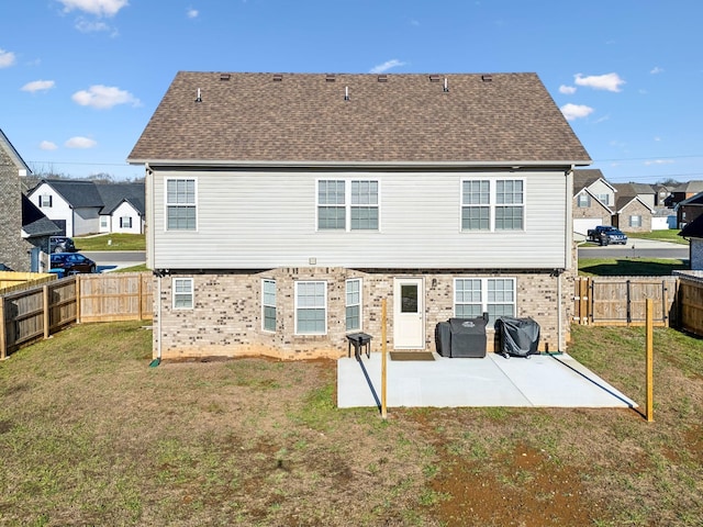 rear view of house featuring a lawn and a patio area