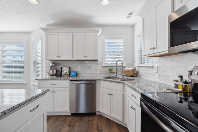 kitchen featuring light stone countertops, sink, white cabinetry, and stainless steel appliances