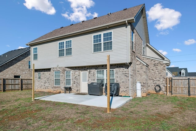 back of property with a lawn and a patio area