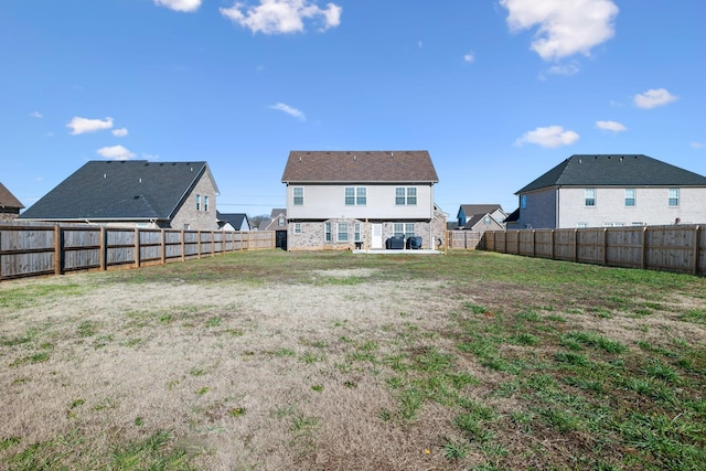 back of house featuring a lawn and a patio area