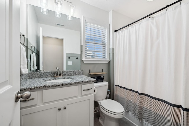 bathroom featuring walk in shower, vanity, and toilet