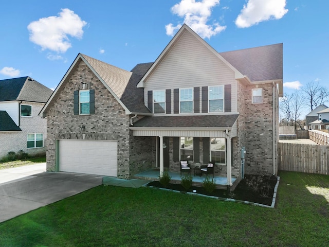 view of front of property featuring a garage, covered porch, and a front yard