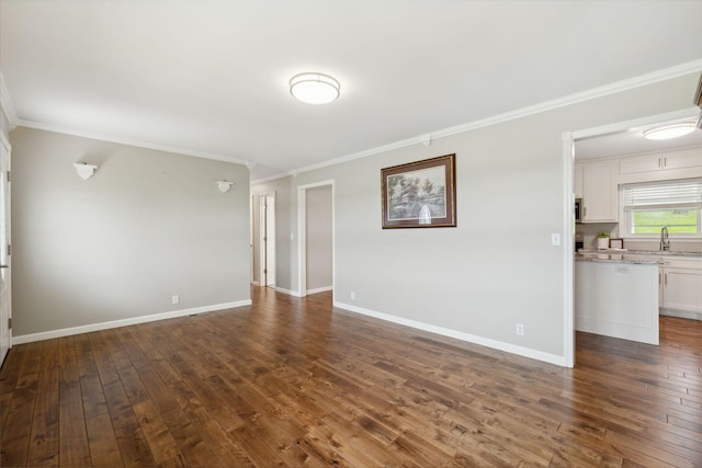 empty room with sink, dark wood-type flooring, and ornamental molding