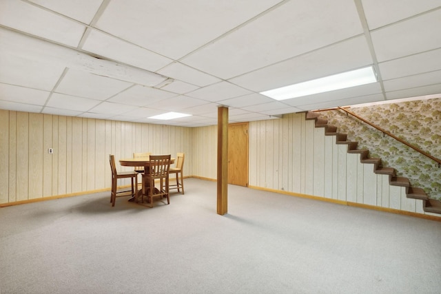 basement with a paneled ceiling and carpet