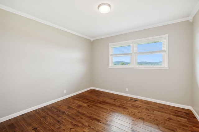 spare room featuring crown molding and wood-type flooring