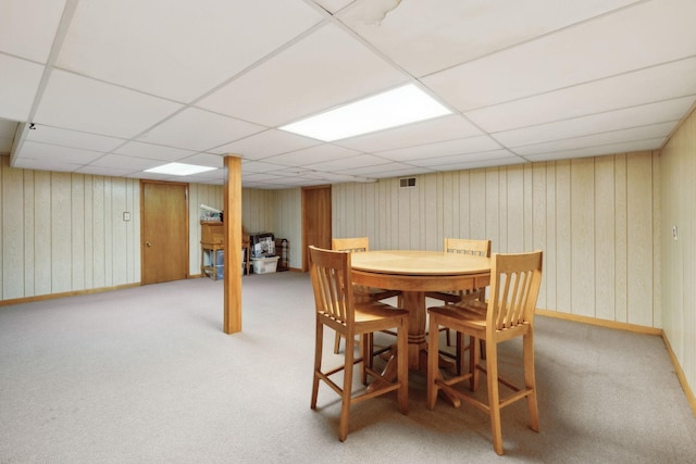 dining space featuring a drop ceiling and light colored carpet