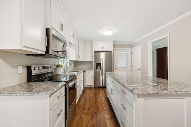 kitchen with a center island, white cabinets, sink, light stone countertops, and stainless steel appliances