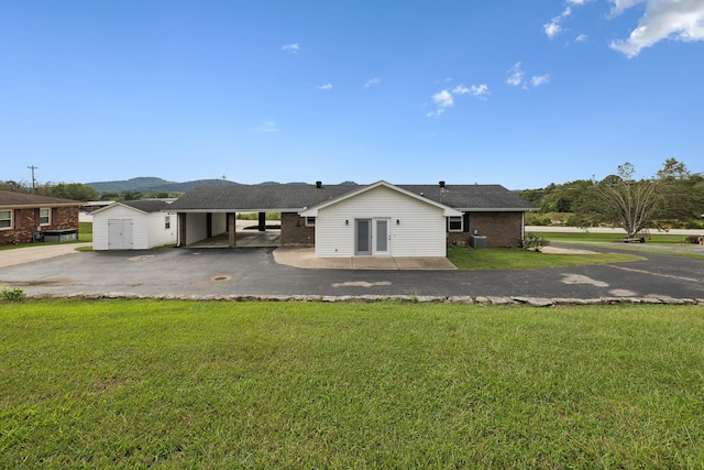 exterior space with a carport, a mountain view, and a front lawn