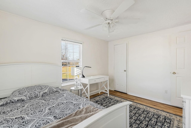 bedroom featuring wood-type flooring, a textured ceiling, and ceiling fan