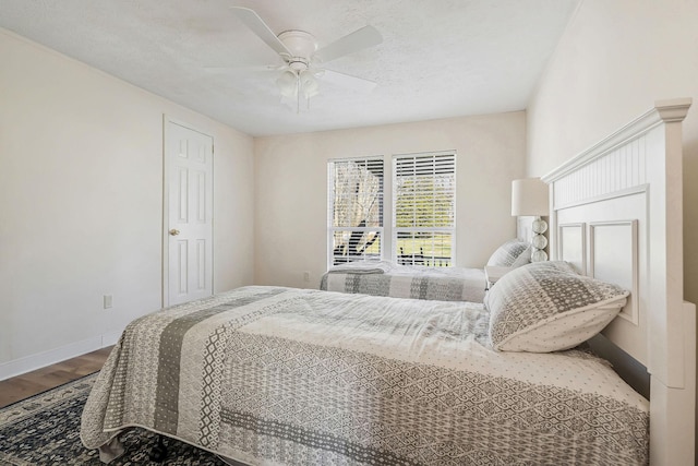 bedroom with hardwood / wood-style floors, a textured ceiling, and ceiling fan