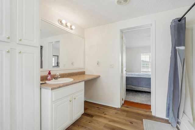 bathroom featuring vanity, wood-type flooring, a textured ceiling, and a shower with shower curtain