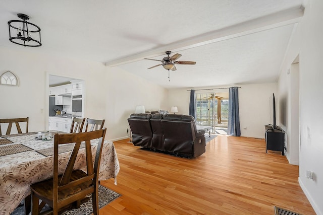 dining area with ceiling fan, light hardwood / wood-style flooring, and beamed ceiling