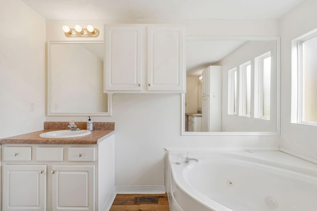 bathroom featuring hardwood / wood-style flooring, vanity, and a bath