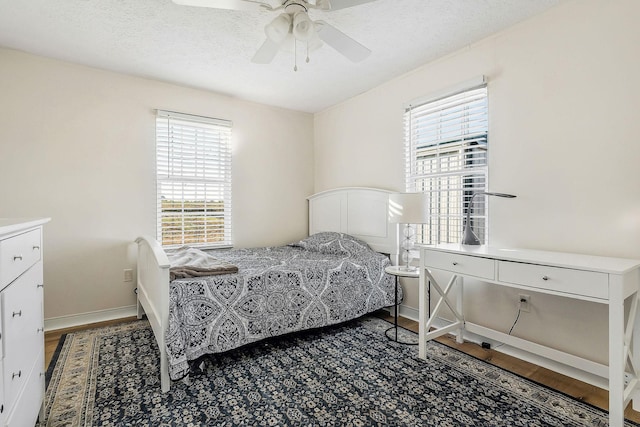 bedroom with ceiling fan, a textured ceiling, and multiple windows