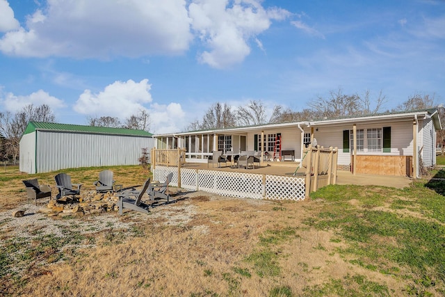 rear view of house with a fire pit and a wooden deck