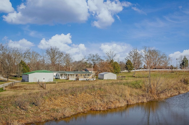 back of house with a storage unit and a water view