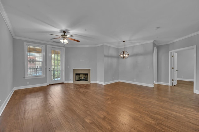 unfurnished living room with ceiling fan with notable chandelier, dark hardwood / wood-style floors, and crown molding