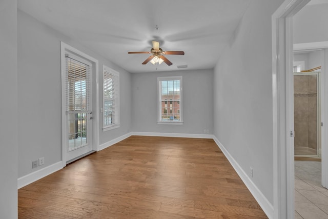 empty room with ceiling fan and light wood-type flooring