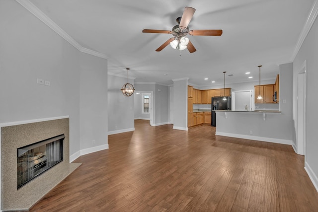 unfurnished living room featuring ceiling fan with notable chandelier, light hardwood / wood-style floors, and ornamental molding