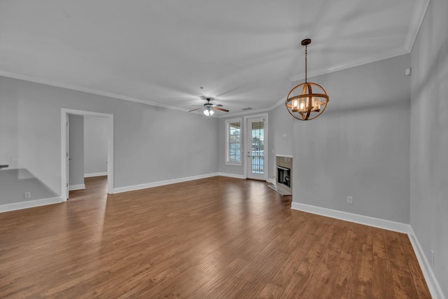 unfurnished living room featuring crown molding, ceiling fan with notable chandelier, and hardwood / wood-style flooring