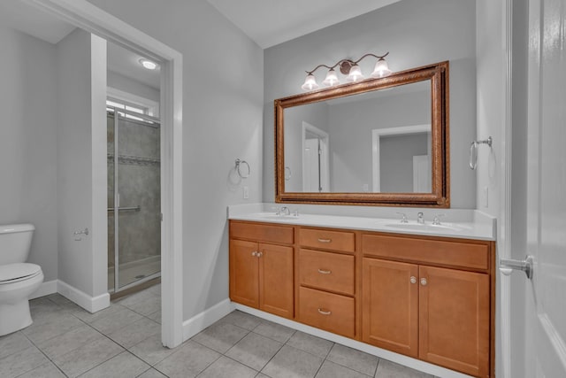 bathroom featuring tile patterned flooring, vanity, toilet, and a shower with door