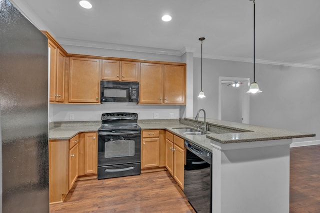 kitchen with kitchen peninsula, sink, hanging light fixtures, and black appliances