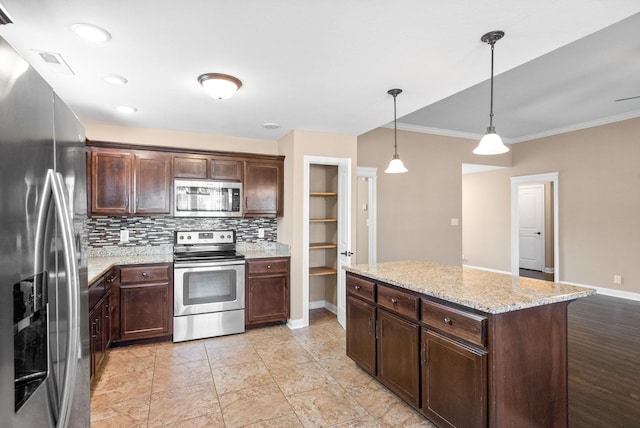 kitchen with light stone countertops, backsplash, dark brown cabinetry, stainless steel appliances, and hanging light fixtures