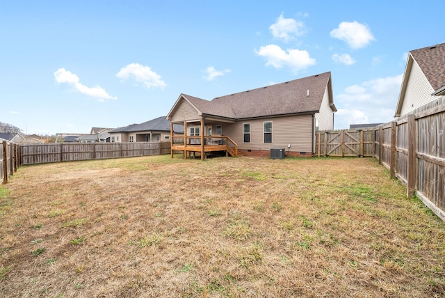 rear view of property with central AC unit, a lawn, and a wooden deck