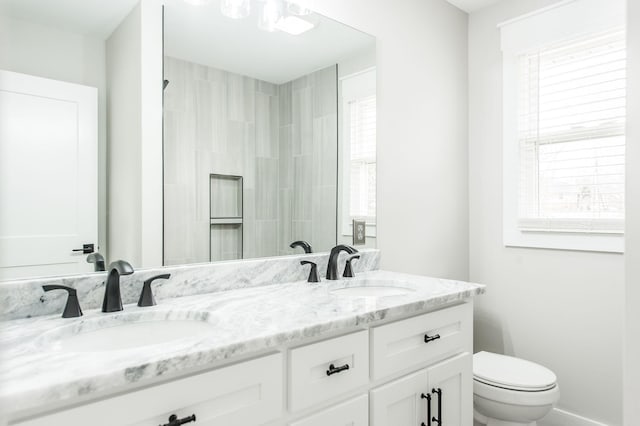 bathroom with a wealth of natural light, vanity, and toilet