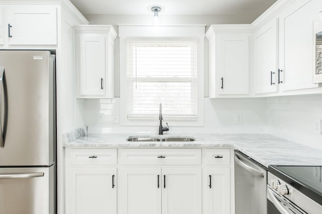 kitchen featuring a wealth of natural light, white cabinetry, sink, and appliances with stainless steel finishes